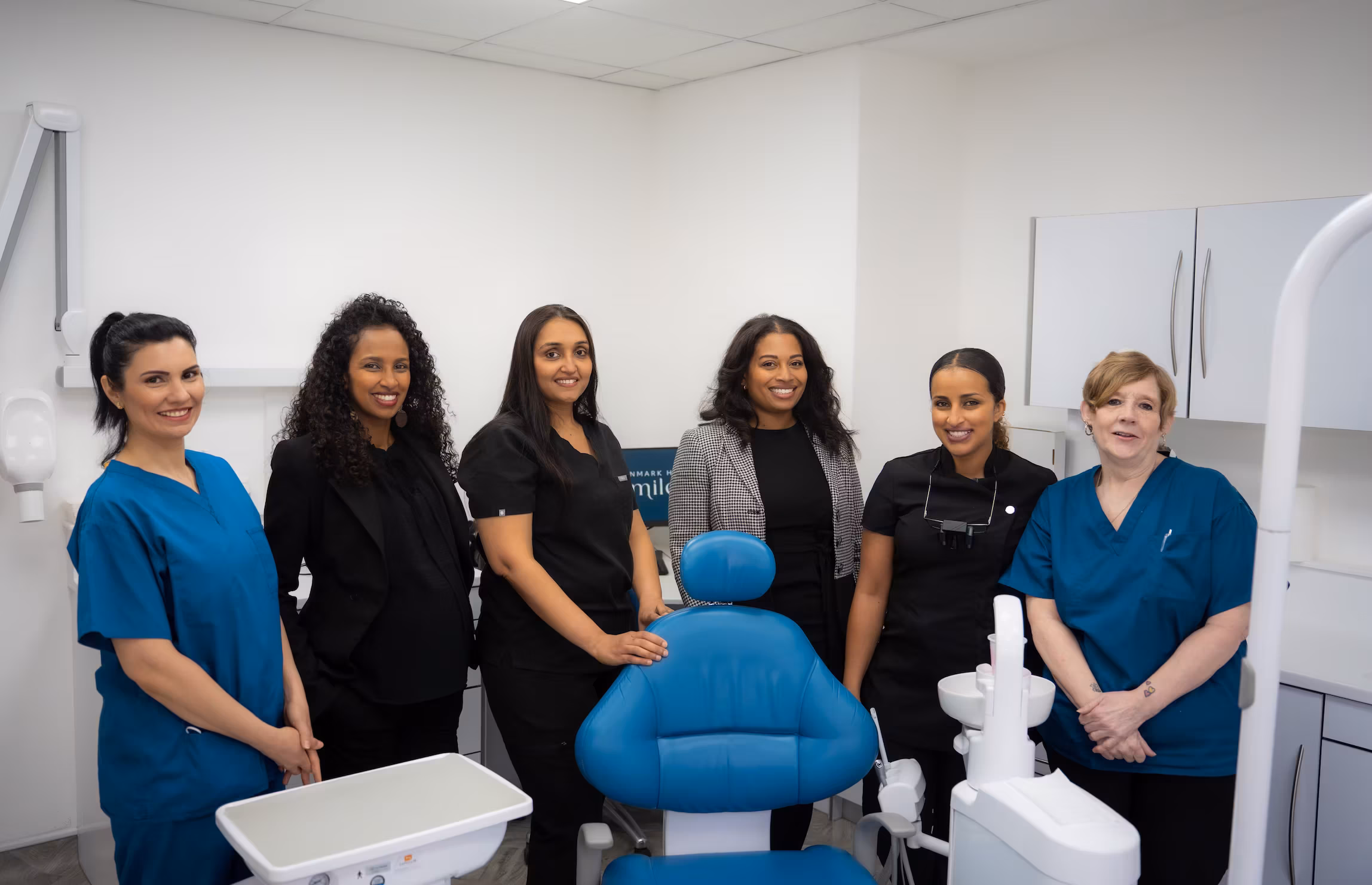All team members smiling together in unison